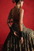 Mohsin Naveed Ranjha Gul-e-Khaas dark green Indian silk lehenga choli featuring a floral printed sleeveless choli with golden embroidery along the neckline and straps, paired with a lehenga layered with appliqués, block-printed motifs, gota patti, mirror work, hand embroidery, and spade-inspired geometric patterns with an ornate golden threadwork hemline, complete with an organza dupatta blooming with printed florals, gota patti, adda work, embroidered borders, kiran trims, and delicate tassels, perfect for