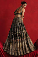 Mohsin Naveed Ranjha Gul-e-Khaas dark green Indian silk lehenga choli featuring a floral printed sleeveless choli with golden embroidery along the neckline and straps, paired with a lehenga layered with appliqués, block-printed motifs, gota patti, mirror work, hand embroidery, and spade-inspired geometric patterns with an ornate golden threadwork hemline, complete with an organza dupatta blooming with printed florals, gota patti, adda work, embroidered borders, kiran trims, and delicate tassels, perfect for