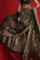 Mohsin Naveed Ranjha Gul-e-Khaas dark green Indian silk lehenga choli featuring a floral printed sleeveless choli with golden embroidery along the neckline and straps, paired with a lehenga layered with appliqués, block-printed motifs, gota patti, mirror work, hand embroidery, and spade-inspired geometric patterns with an ornate golden threadwork hemline, complete with an organza dupatta blooming with printed florals, gota patti, adda work, embroidered borders, kiran trims, and delicate tassels, perfect for