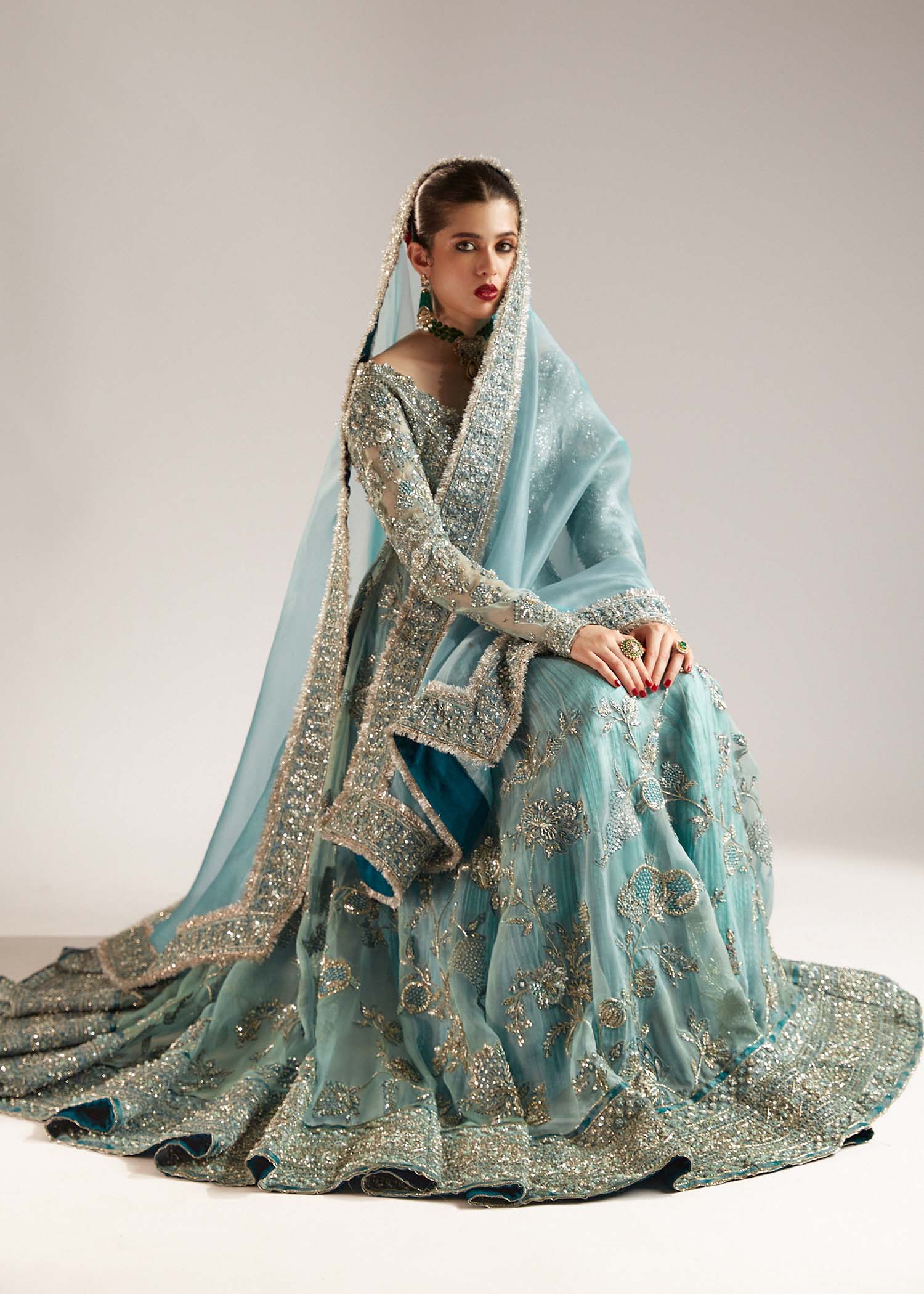 Hussain Rehar Astra ice-blue organza peshwas featuring intricate embellishments on the front and back bodice with heavy embellished borders, paired with a resplendent silk crushed sharara and a digital printed organza dupatta with celestial motifs and four-sided embellished border, perfect for weddings and formal celebrations.
