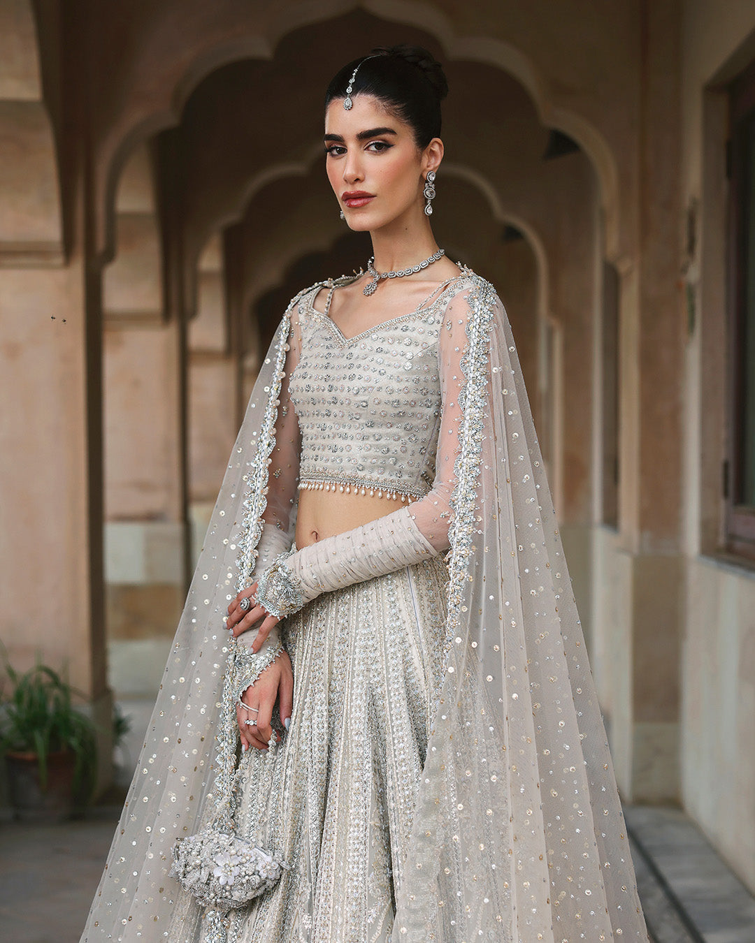 Faiza Saqlain Cammi soft ivory ensemble featuring intricately handworked detailing and delicate embellishments on a flowing silhouette, paired with a sheer dupatta, perfect for weddings and formal occasions.