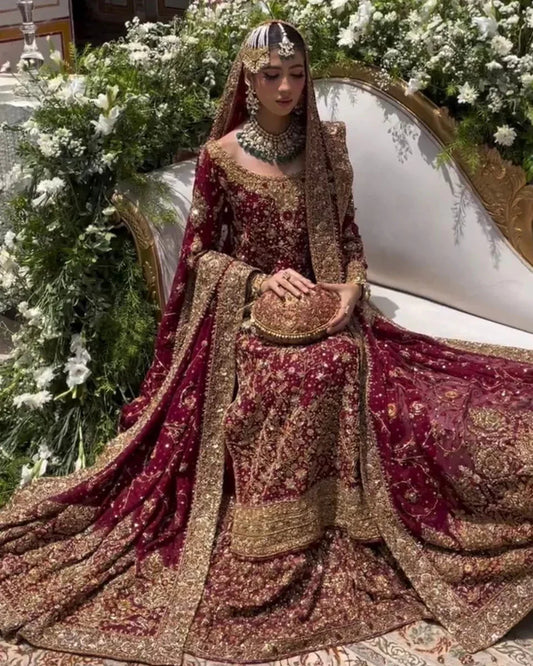 Haris Shakeel Ishq Series bridal ensemble in deep romantic maroon featuring intricate adda work and hand embellishment with fine dabka and handworked motifs spread generously across the shirt, sleeves, and flowing lehenga with richly embellished borders, paired with a heavily worked dupatta with ornate edging, perfect for brides seeking classic sophistication and traditional grandeur.