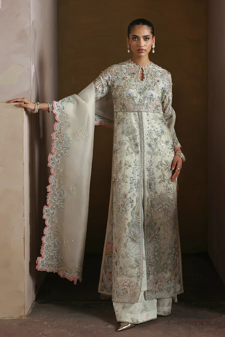 Soraya Novara ivory and gold formal ensemble featuring a beautifully embellished shirt with intricate handwork blending delicate thread embroidery, shimmering sequins, and fine embellishments on a soft ivory base with detailed gold accents, paired with a complementing dupatta, perfect for weddings, receptions, engagement ceremonies, and festive celebrations.