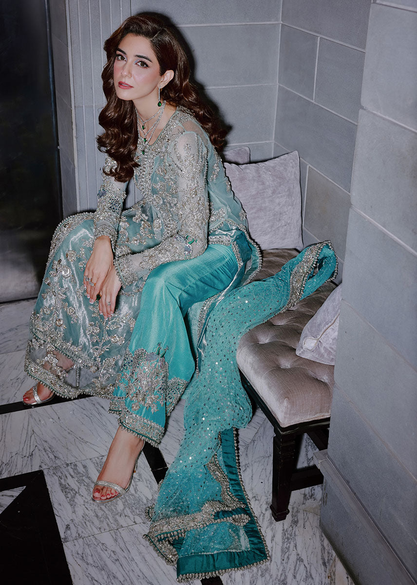 Sara Rohale Asghar Ferozeah aqua long shirt featuring intricate silver embellishments with hand-embroidered floral motifs creating a refined jal, paired with a sheer dupatta with heavily embellished border and scattered sequins, and straight-cut azar trousers with bejeweled peacock hem in silver threadwork, perfect for formal occasions and statement looks.